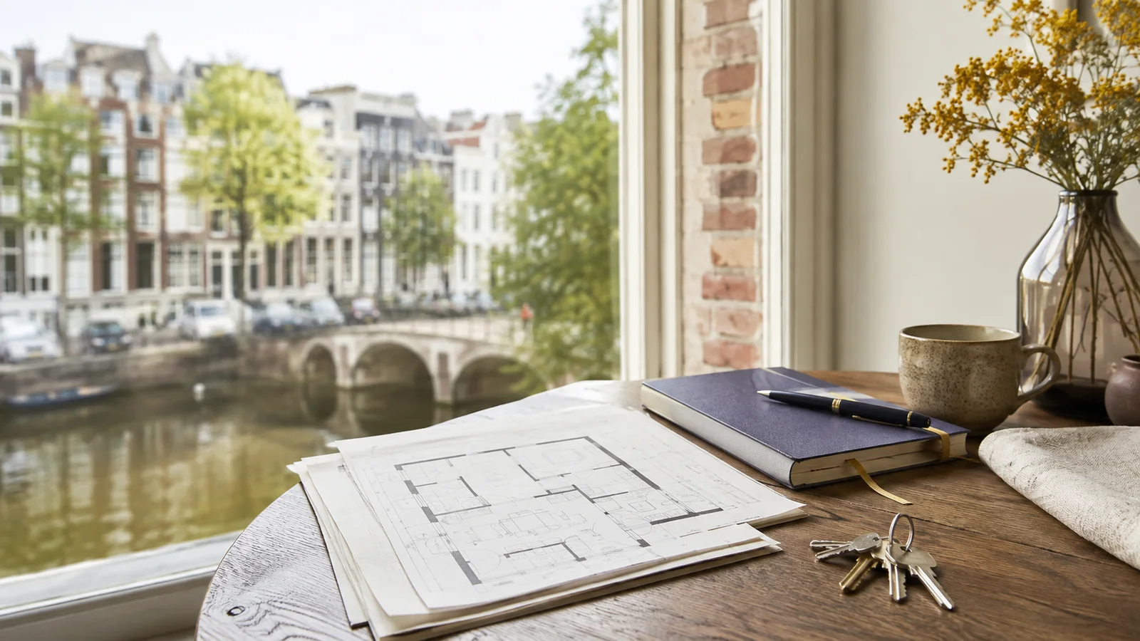 Amsterdam home-buying documents and a checklist arranged beside a canal home view